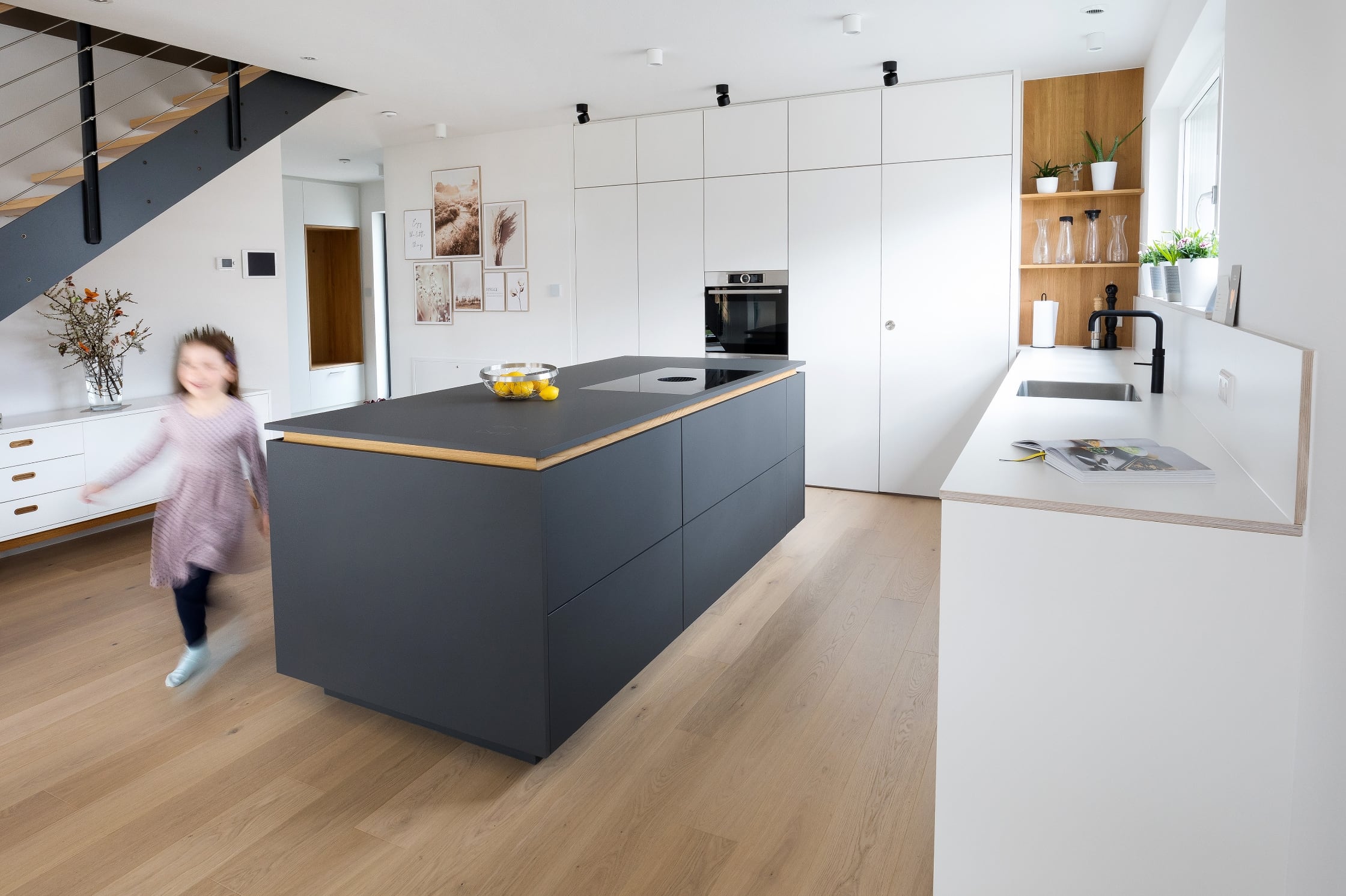 Weiße Küche mit schwarzer Kücheninsel und Holzelementen in Crailsheim von NR Küchen Küchenstudio Crailsheim