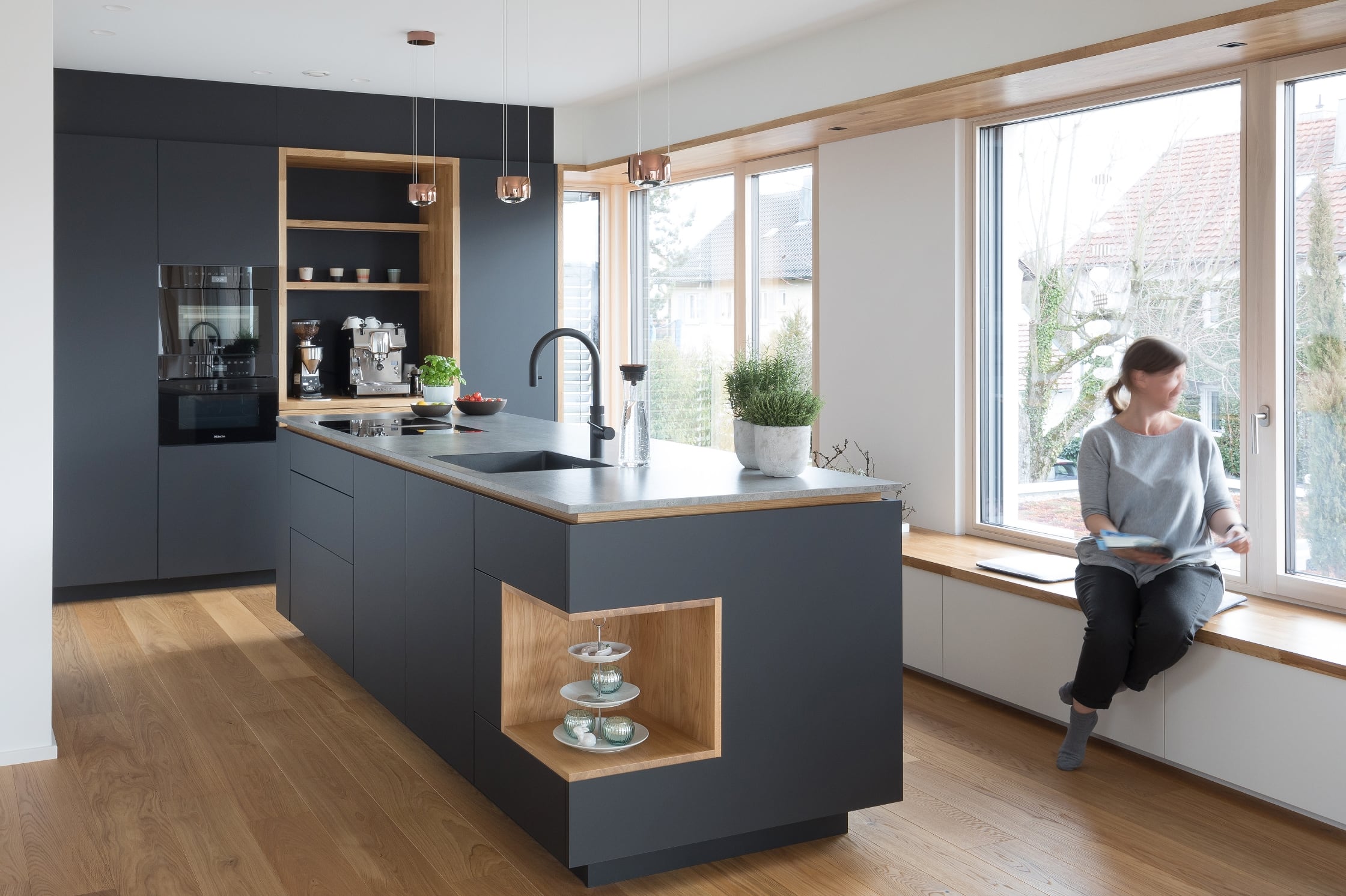 Schwarze offene Küche mit Holzelementen von NR Küchen Küchenstudio Ludwigsburg